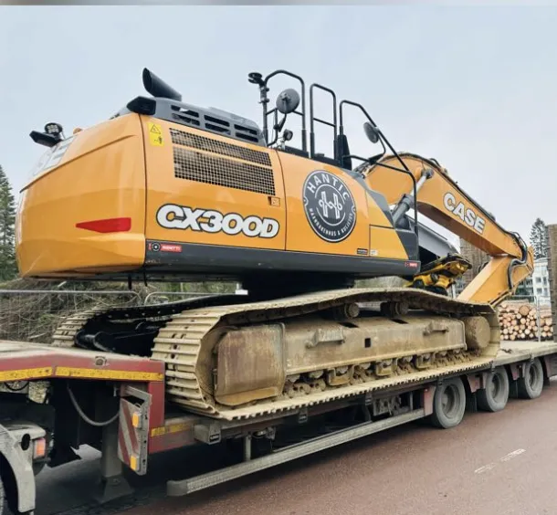 Rakennuskone CX300D keltaisella värillä lastattuna kuorma-auton lavalle.